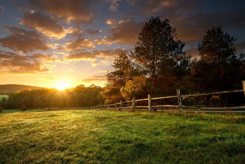 Fototapeta Malowniczy krajobraz, ogrodzony ranczo o wschodzie słońca