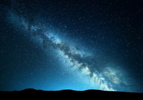 Fototapeta Nocny krajobraz z niesamowitą drogą mleczną w górach. niebieski noc gwiaździste niebo ze wzgórzami w lecie. piękna galaktyka. wszechświat. tło przestrzeni