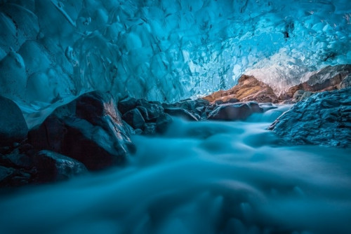 Fototapeta Grotta di ghiaccio azzurro con ruscello sottostante islanda europa