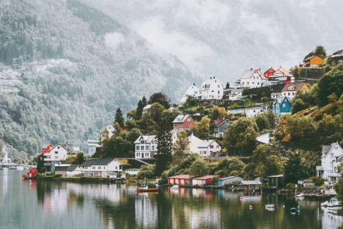 Fototapeta Dziwne domy miasta w Norwegii krajobraz mglisty gór i refleksji wody.