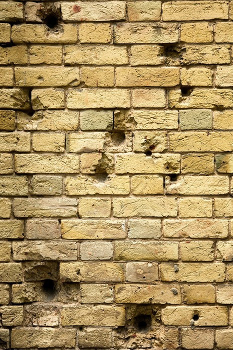 Fototapeta Dziury po kulach w ścianie z cegły