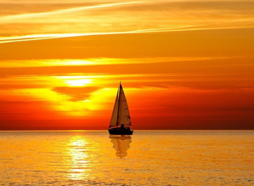Fototapeta Jacht na tle pomarańczowego zachodu słońca