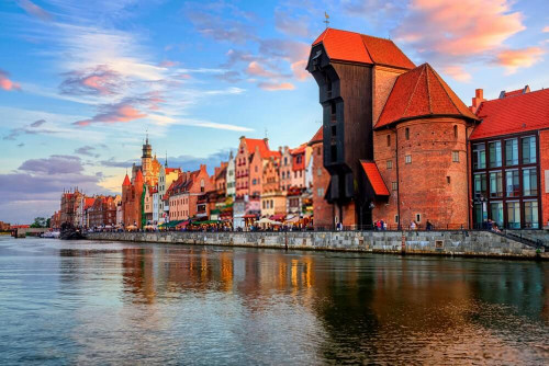 Fototapeta Żuraw i gotyckie stare miasto o zachodzie słońca